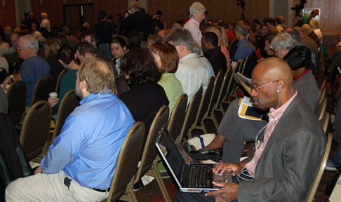 participants in the ballroom waiting for conference to begin